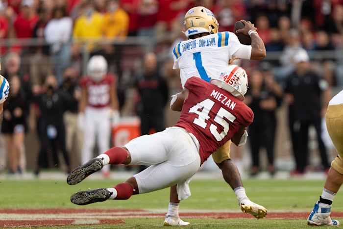 Stanford Cardinal linebacker Ricky Miezan (45) tackles UCLA Bruins quarterback Dorian Thompson-Robinson (1) during the third quarter at Stanford Stadium.
